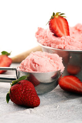 Strawberry ice cream scoop on a rustic white background with fresh strawberries