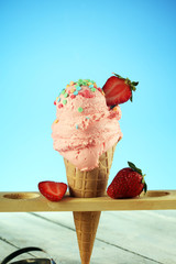 Strawberry ice cream scoop on a rustic white background with fresh strawberries