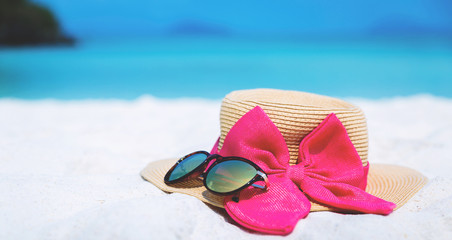 Straw hat and sun glasses on beach