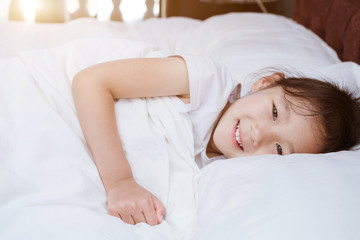 Fototapeta na wymiar Chinese girl in white dress lying in bed
