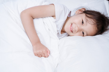 Fototapeta na wymiar Chinese girl in white dress lying in bed