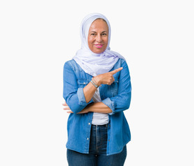 Middle age eastern arab woman wearing arabian hijab over isolated background Pointing with hand finger to the side showing advertisement, serious and calm face