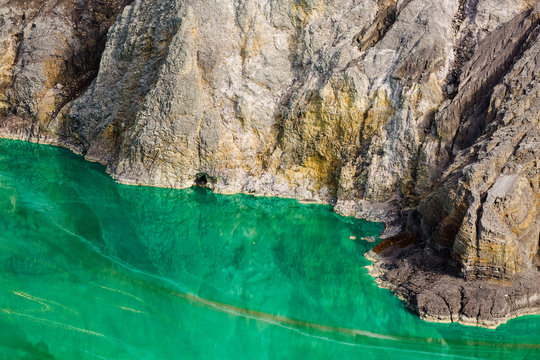 Shot of the shore of a green sulfur lake in the crater of the Kawah Ijen volcano in Indonesia