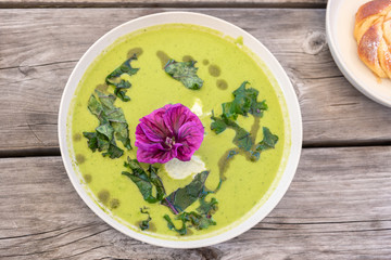 View of a cress soup with an edible flower.