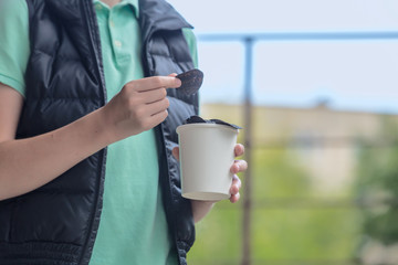 Black chips. Black potato chips in the hands of a teenager on the background of a sunny summer landscape.