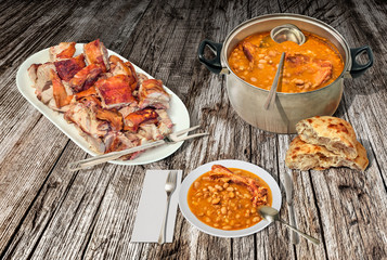 Plateful Of Spit Roasted Pork Meat Chunks Served with Baked Beans and Domestic Pita Leavened Flatbread on Old Weathered Rustic Pinewood Table