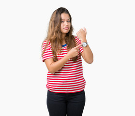 Young beautiful brunette woman wearing stripes t-shirt over isolated background In hurry pointing...