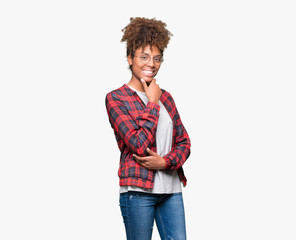 Beautiful young african american woman wearing glasses over isolated background looking confident...