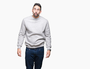 Fototapeta premium Young handsome man wearing sweatshirt over isolated background making fish face with lips, crazy and comical gesture. Funny expression.