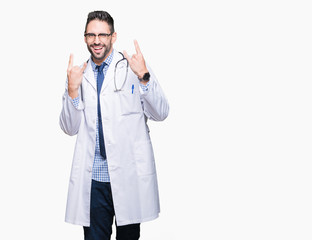 Handsome young doctor man over isolated background shouting with crazy expression doing rock symbol with hands up. Music star. Heavy concept.