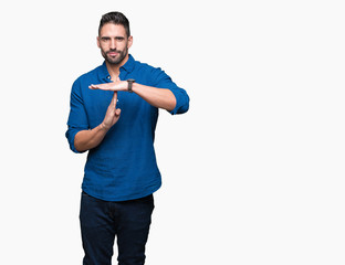 Young handsome man over isolated background Doing time out gesture with hands, frustrated and...