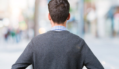 Young handsome smart man wearing glasses over isolated background standing backwards looking away with arms on body