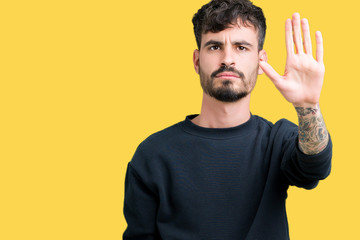 Young handsome man over isolated background doing stop sing with palm of the hand. Warning...