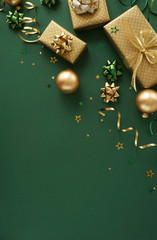 christmas or new year frame decorations in gold colors on dark green color background with empty...