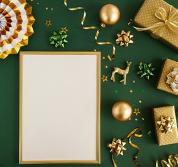 christmas or new year frame decorations in gold colors on dark green background with empty copy space for text in frame mock up. holiday and celebration concept for postcard or invitation. top view 