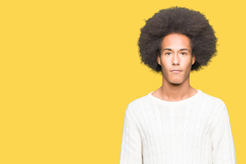 Fototapeta na wymiar Young african american man with afro hair wearing winter sweater Relaxed with serious expression on face. Simple and natural looking at the camera.