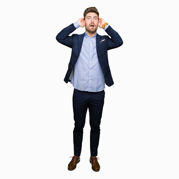 Young handsome bussines man Crazy and scared with hands on head, afraid and surprised of shock with open mouth
