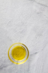 Olive oil in glass bowl isolated on stone surface