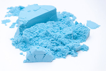 Closeup og blue kinetic sand on the white background. Kids development concept.