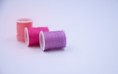 In selective focus of soft purple color thread put on white background,blurry light around
