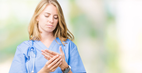 Beautiful young doctor woman wearing medical uniform over isolated background Suffering pain on...