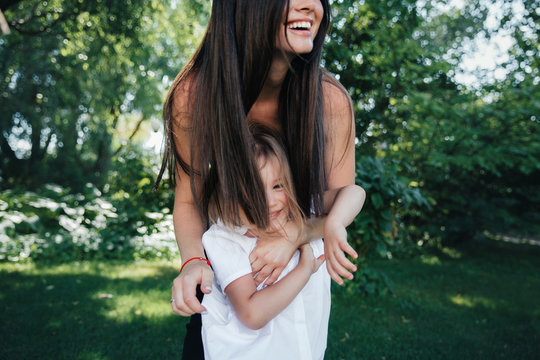 mother with daughter in white clothes are having fun in the park