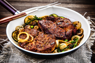 Grilled steak, baked potatoes and vegetables