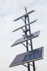 Solar station stands in a park on a winter cloudy day. Solar panels and wind turbines that generate electricity in a renewable green power plant against a cloudy sky in winter.