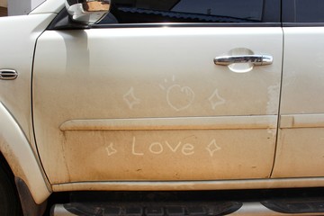 The white car has a heart shape and the words love on the car door, take a blurred picture