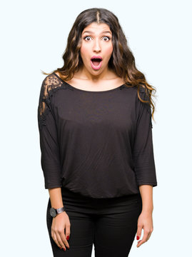 Beautiful young woman with long hair afraid and shocked with surprise expression, fear and excited face.