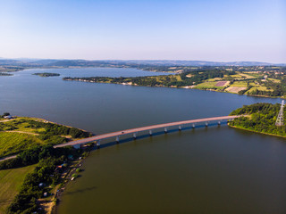 Fototapeta premium Aerial view of lake, forest and agriculture field by the water, at summer. Gruza lake near the Kragujevac in Serbia.