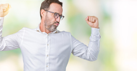 Naklejka premium Handsome middle age elegant senior business man wearing glasses over isolated background showing arms muscles smiling proud. Fitness concept.