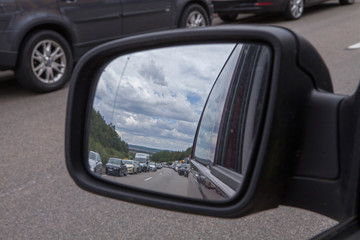 Fototapeta na wymiar Highway Germany Autobahn. Stau. Traffice jam seen from the rear view morror. Automotive. Cars.