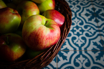 basket of apple on kitchen tile floor, vignette frame