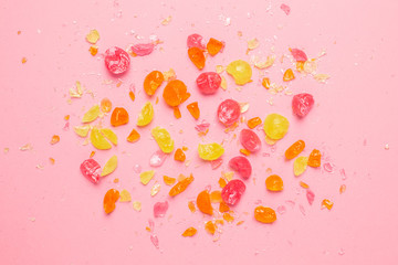 Multicolor sweet lollipops bitten pieces set on pink background.