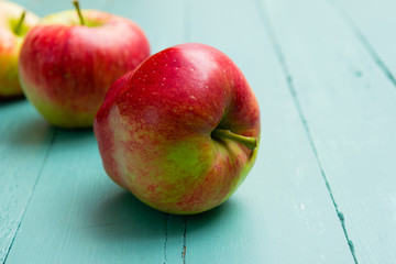 three apples on blue wooden background