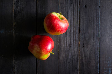 two apples on black wooden background