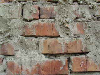 Old brick wall close-up. Uneven brick masonry. Example of poor work. Brick wall background.  Red...
