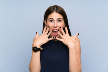 Young woman over isolated blue wall with surprise facial expression