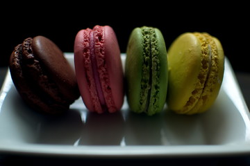 Multi-colored macaroons on a wooden tray. Pink, yellow and green macaroon. - 278224619