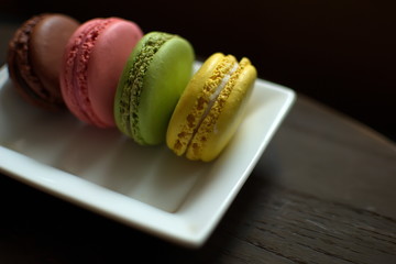Multi-colored macaroons on a wooden tray. Pink, yellow and green macaroon. - 278224651