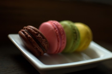 Multi-colored macaroons on a wooden tray. Pink, yellow and green macaroon. - 278224664
