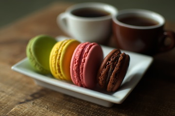Multi-colored macaroons on a wooden tray. Pink, yellow and green macaroon. - 278224821