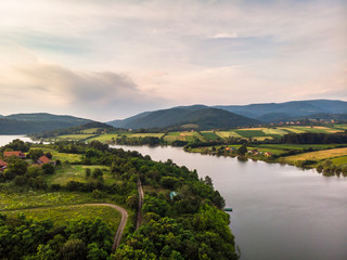 Obraz premium Aerial view of lake, forest and agriculture field by the water, at summer. Gruza lake near the Kragujevac in Serbia.