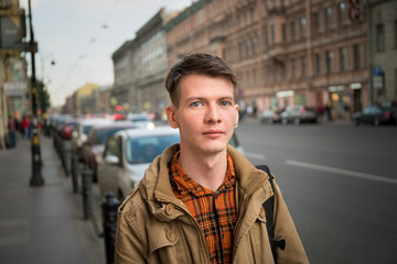 Portrait of handsome young man walking on the street and looking at camera.