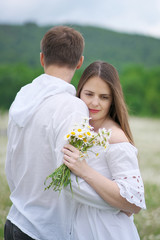 Happy couple on camomile meadow.