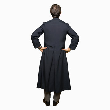 Middle age priest man wearing catholic robe standing backwards looking away with arms on body