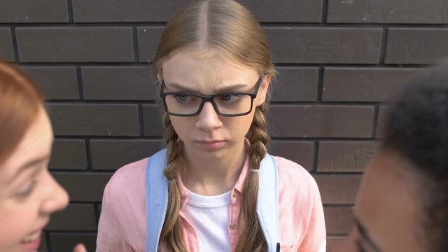 Classmates laughing at pretty girl in eyeglasses, malicious teasing, bullying