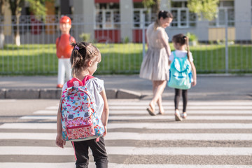 Back to school education concept with girl kids, elementary students, carrying backpacks going to class