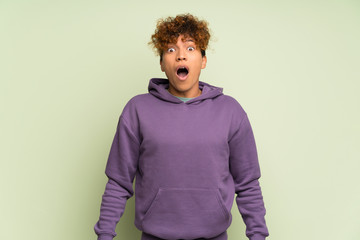 Young african american man over isolated green wall with surprise facial expression